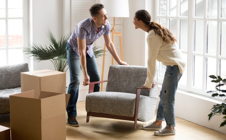 Smiling,Couple,Carrying,Modern,Chair,Together,Placing,Furniture,Moving,Into